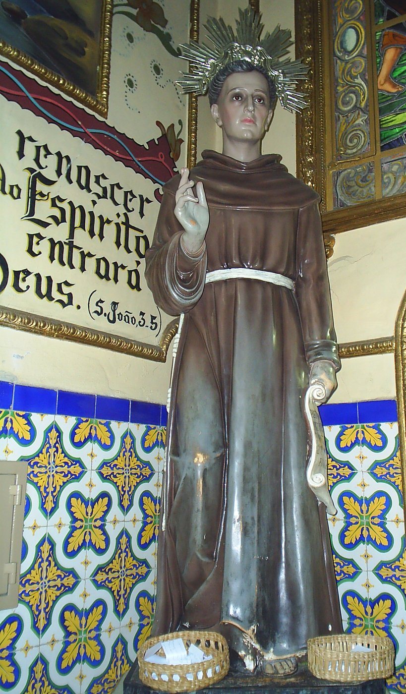 Imagem de Frei Galvão no santuário de Guaratinguetá, com os cestos das pílulas de oração aos seus pés