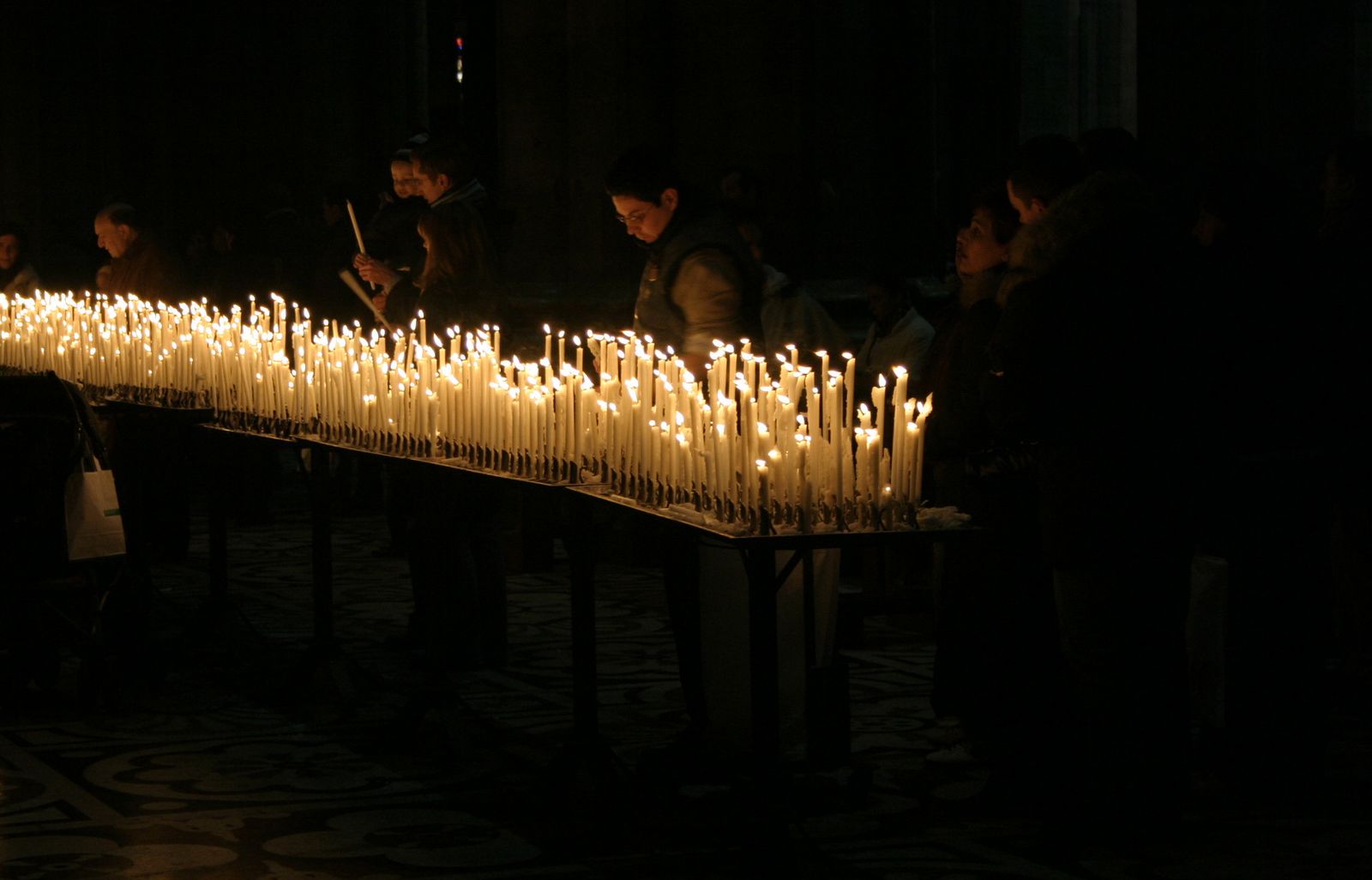 Parede de velas acesas dentro de uma igreja